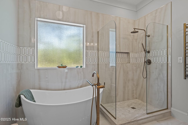 full bathroom with walk in shower and a freestanding bath