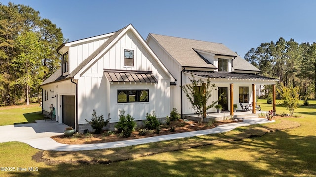 view of front facade with a porch, an attached garage, a standing seam roof, and a front lawn
