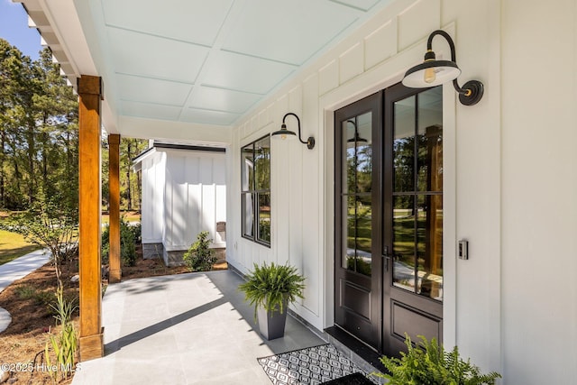 property entrance with board and batten siding, french doors, and a porch