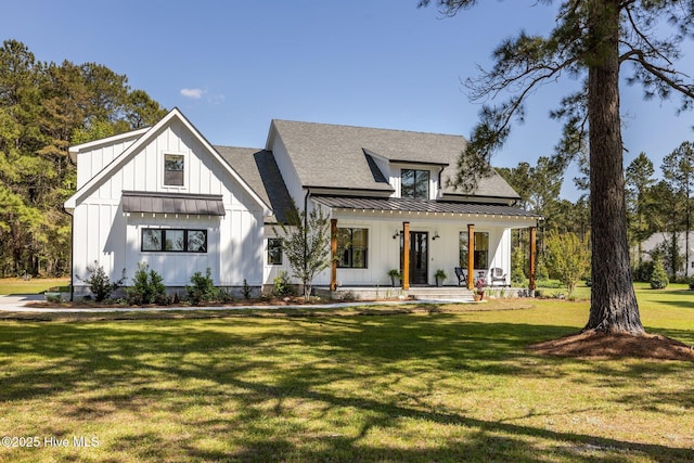 modern farmhouse style home featuring a standing seam roof, board and batten siding, a porch, and a front lawn