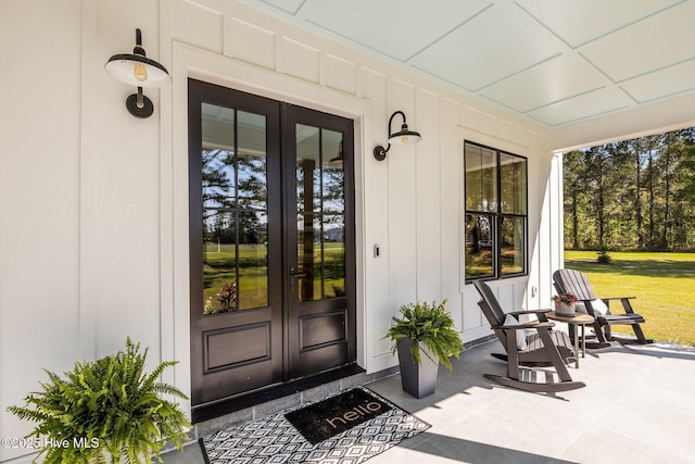 property entrance featuring covered porch and french doors