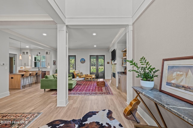 entryway featuring recessed lighting, baseboards, crown molding, and light wood finished floors