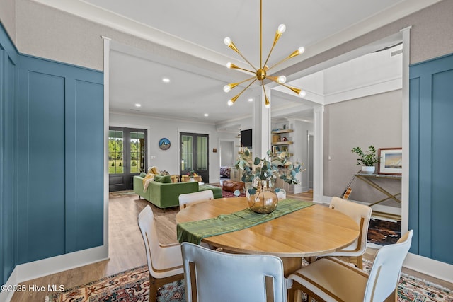 dining space featuring crown molding, wood finished floors, and a notable chandelier