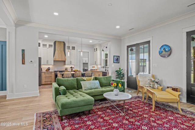 living area with light wood-style floors, crown molding, recessed lighting, and visible vents
