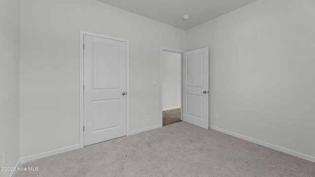 unfurnished bedroom featuring carpet floors and baseboards