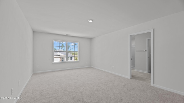 unfurnished room featuring carpet floors and baseboards