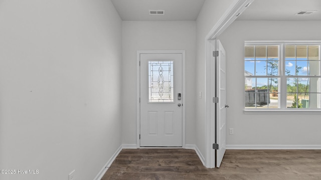 doorway to outside featuring visible vents, baseboards, and wood finished floors