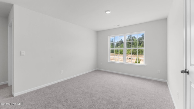 spare room featuring baseboards and carpet