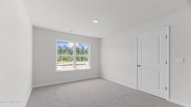 empty room featuring baseboards, visible vents, and carpet