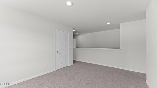 spare room featuring carpet flooring, recessed lighting, and baseboards