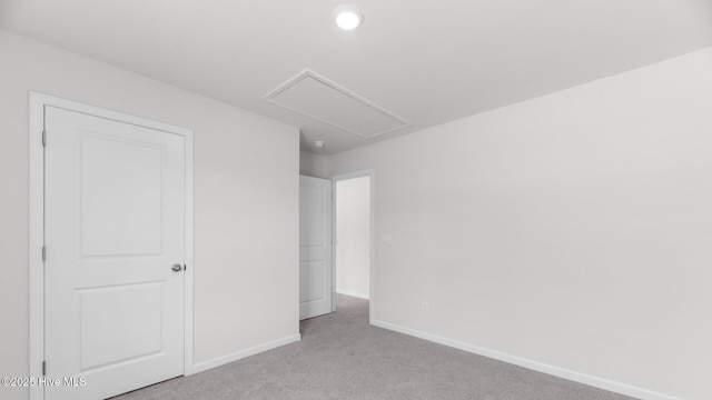 unfurnished bedroom with baseboards, carpet, and attic access