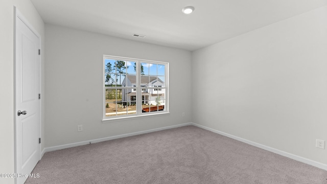 carpeted empty room featuring baseboards and visible vents
