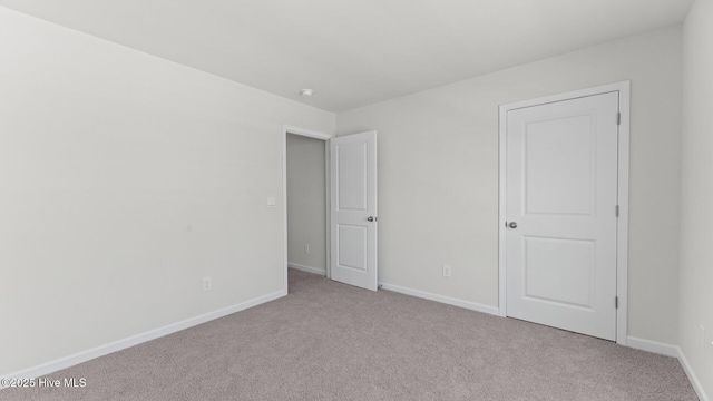 unfurnished bedroom featuring carpet floors and baseboards