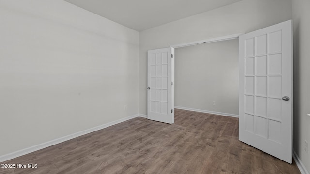 unfurnished room with baseboards and wood finished floors