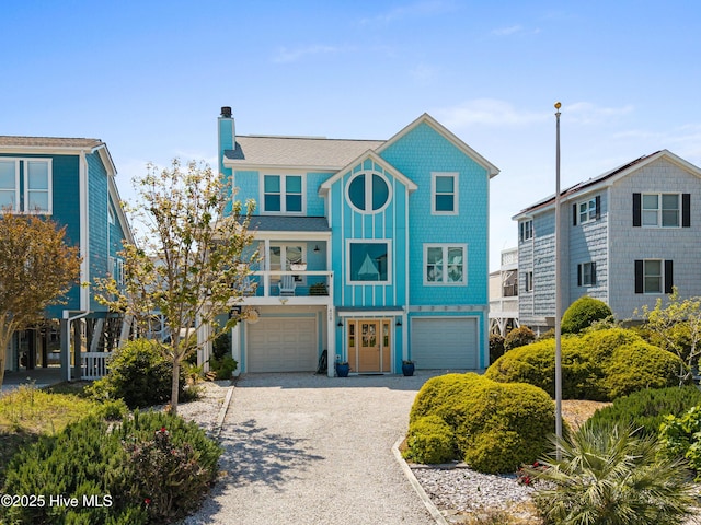 408 Dolphin St, Sunset Beach, NC 28468 - coastal inspired home with an attached garage, driveway, a chimney, and a balcony