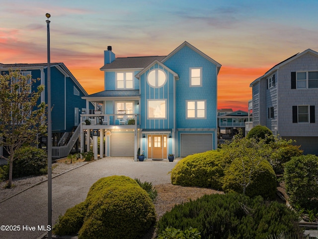 408 Dolphin St, Sunset Beach, NC 28468 - raised beach house featuring stairway, driveway, a chimney, and a garage