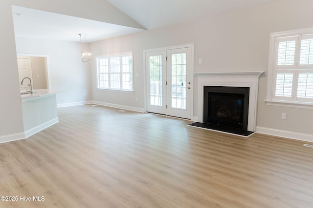 135 Live Oak Dr, Leland, NC 28451 - unfurnished living room featuring a healthy amount of sunlight, light wood finished floors, a fireplace, and a sink