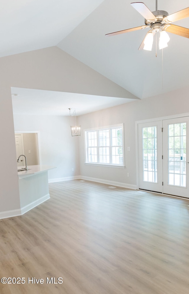 135 Live Oak Dr, Leland, NC 28451 - unfurnished living room featuring baseboards, light wood-style floors, a healthy amount of sunlight, and high vaulted ceiling