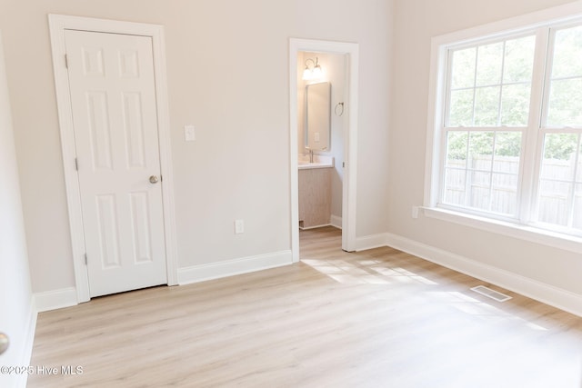 135 Live Oak Dr, Leland, NC 28451 - unfurnished bedroom with light wood-style flooring, baseboards, ensuite bathroom, visible vents, and a sink