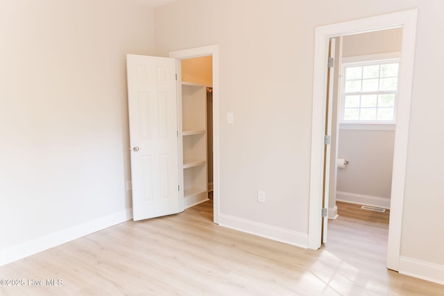135 Live Oak Dr, Leland, NC 28451 - unfurnished bedroom featuring a closet, visible vents, a spacious closet, baseboards, and light wood-style floors