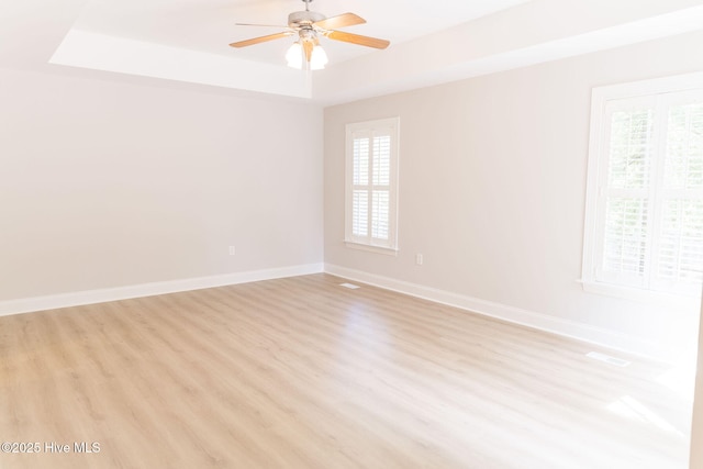 135 Live Oak Dr, Leland, NC 28451 - unfurnished room featuring a healthy amount of sunlight, a tray ceiling, ceiling fan, and light wood-style flooring
