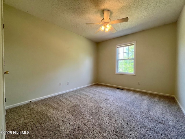 carpeted spare room with a ceiling fan, baseboards, and a textured ceiling