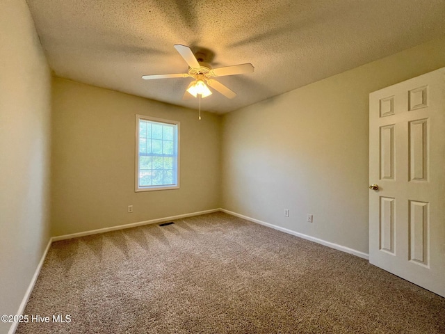 carpeted empty room featuring ceiling fan, a textured ceiling, and baseboards
