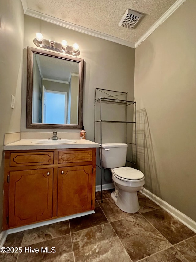 bathroom featuring toilet, baseboards, ornamental molding, vanity, and a textured ceiling