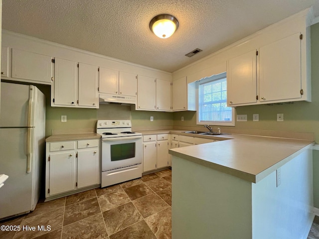 kitchen featuring white appliances, a sink, a peninsula, a textured ceiling, and white cabinetry
