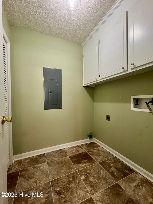 laundry room with electric panel, hookup for an electric dryer, cabinet space, a textured ceiling, and baseboards