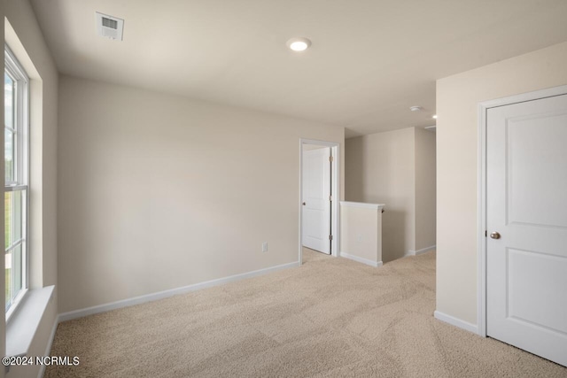 carpeted empty room featuring visible vents, baseboards, and plenty of natural light