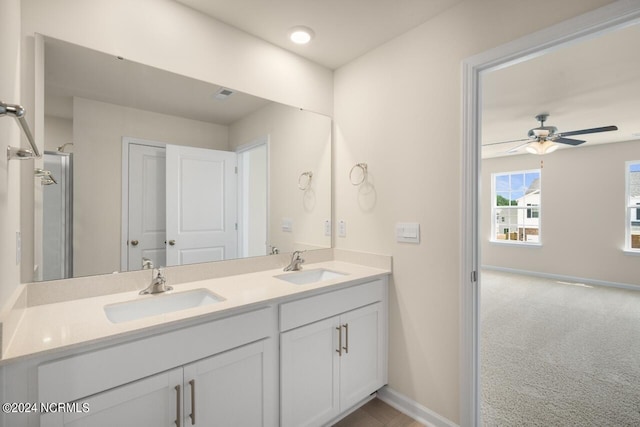 bathroom with a sink, baseboards, a ceiling fan, and double vanity