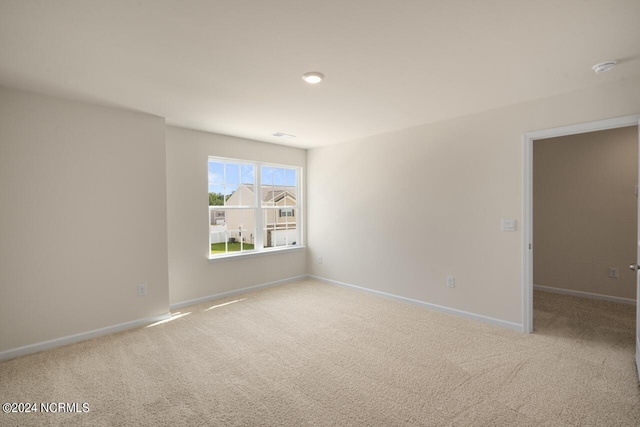 unfurnished room featuring carpet flooring and baseboards