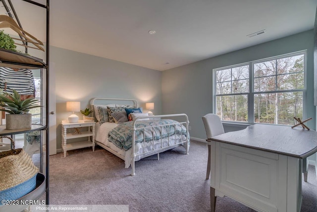 bedroom with baseboards, visible vents, and carpet