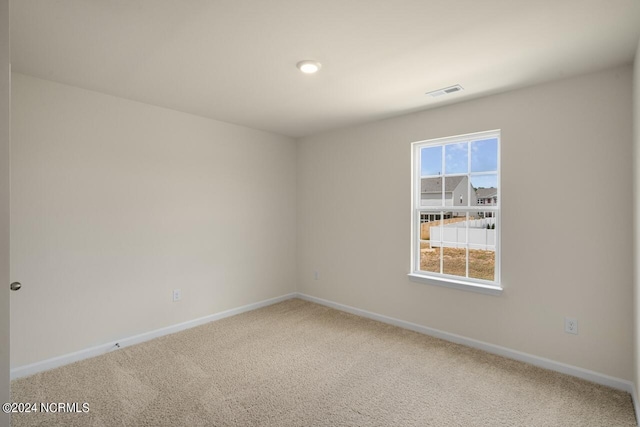 carpeted empty room with baseboards and visible vents