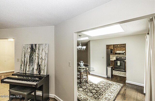 7730 Old Raleigh Rd, Bailey, NC 27807 - hallway featuring dark wood finished floors, an inviting chandelier, and a textured ceiling