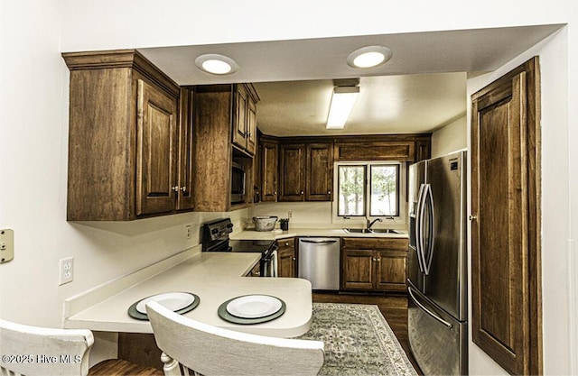 7730 Old Raleigh Rd, Bailey, NC 27807 - kitchen with dark wood finished floors, a sink, dark brown cabinetry, light countertops, and appliances with stainless steel finishes