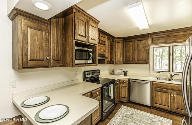 7730 Old Raleigh Rd, Bailey, NC 27807 - kitchen featuring stainless steel appliances, under cabinet range hood, dark wood finished floors, a sink, and light countertops
