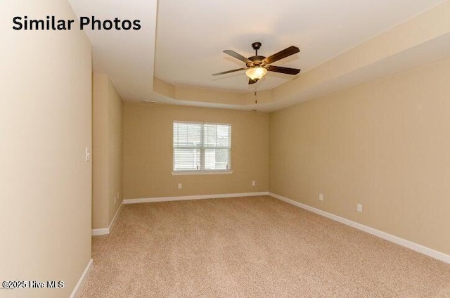 153 Tides End Dr, Holly Ridge, NC 28445 - spare room with light carpet, a ceiling fan, a raised ceiling, and baseboards
