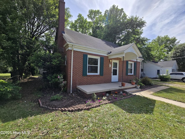 1208 E Holly St, Goldsboro, NC 27530 - bungalow-style home with brick siding, a front lawn, and a chimney