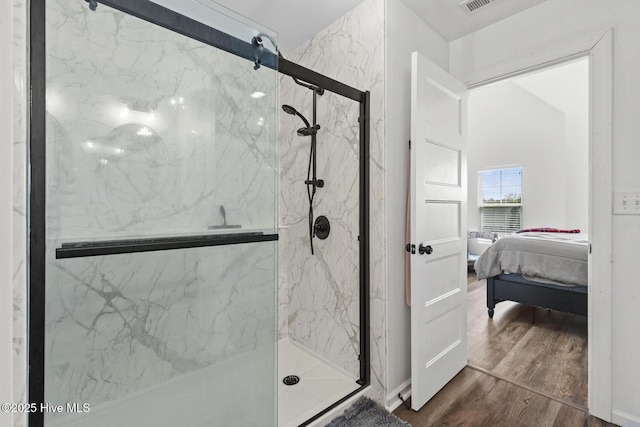 ensuite bathroom featuring a marble finish shower, ensuite bathroom, and wood finished floors