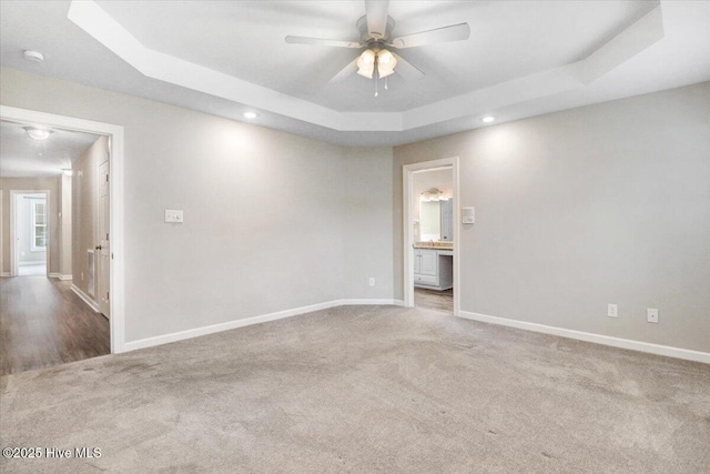 carpeted spare room with baseboards, a ceiling fan, a tray ceiling, and recessed lighting