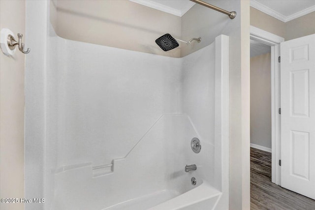 bathroom with crown molding, baseboards, shower / bathing tub combination, and wood finished floors