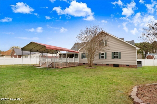 rear view of property featuring a detached carport, fence, a yard, and crawl space