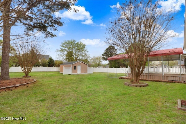 view of yard with an outdoor structure, a fenced backyard, and a shed