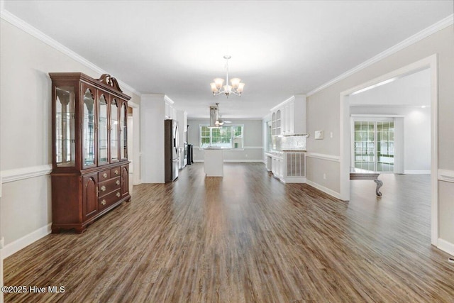 interior space with an inviting chandelier, dark wood-style flooring, crown molding, and baseboards