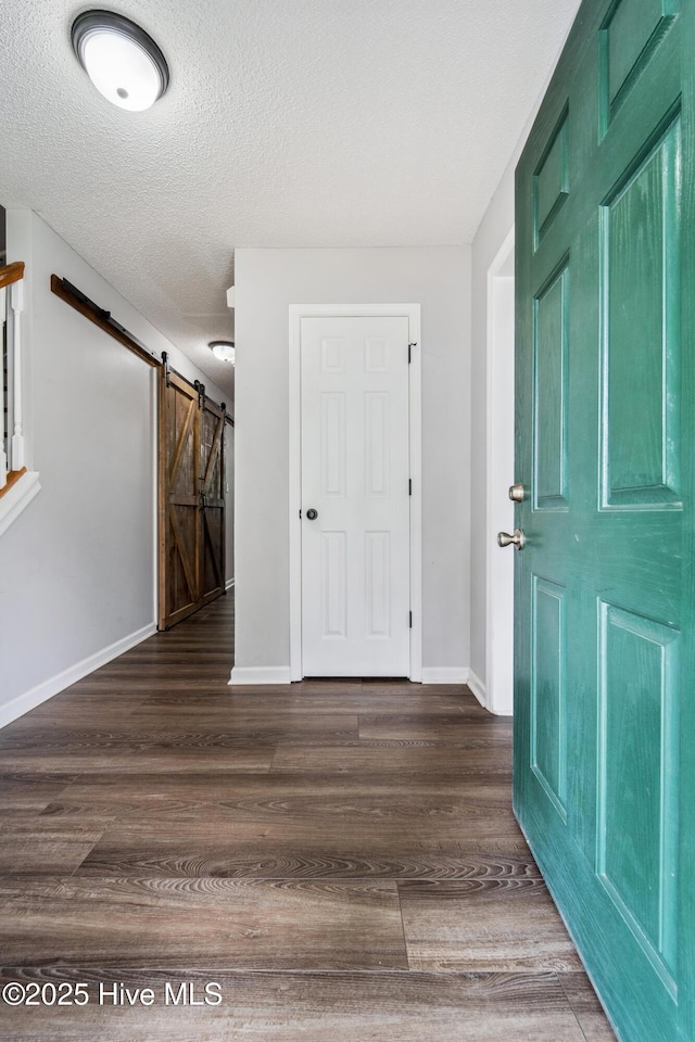 entryway with baseboards, a textured ceiling, and wood finished floors