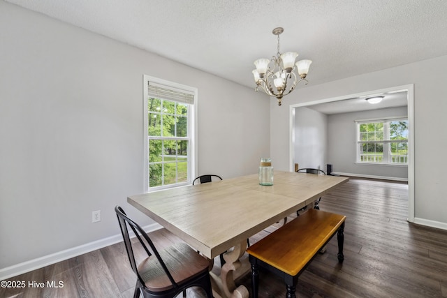 dining room featuring a textured ceiling, baseboards, a notable chandelier, and dark wood-style floors