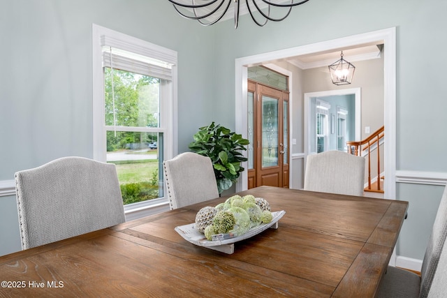 dining space featuring ornamental molding and a notable chandelier