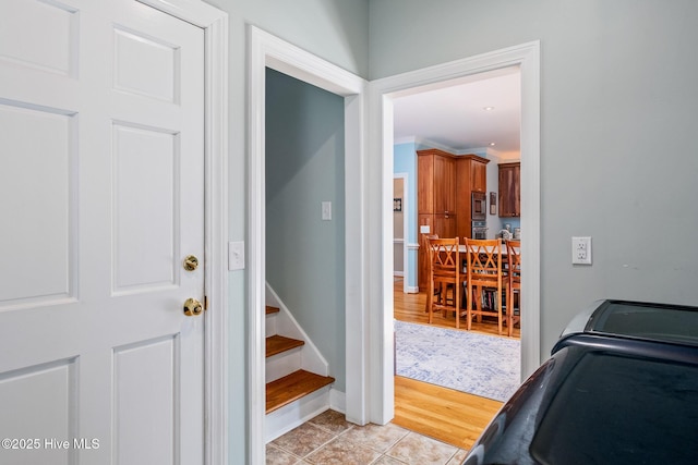corridor with light tile patterned floors and baseboards